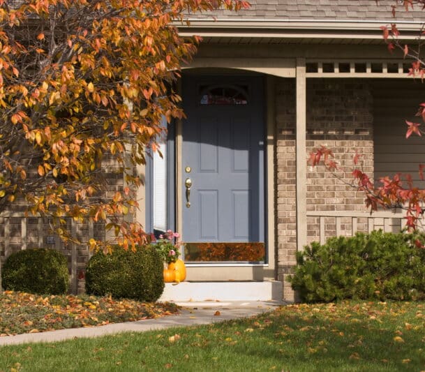 Blue six-panel entry door with arched transom window installed on a brick home in Kitimat, BC — HTR Windows and Doors