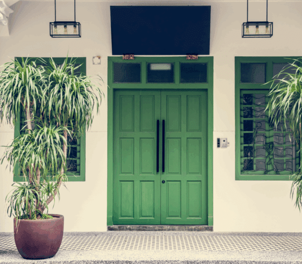 Green door with potted plants outside