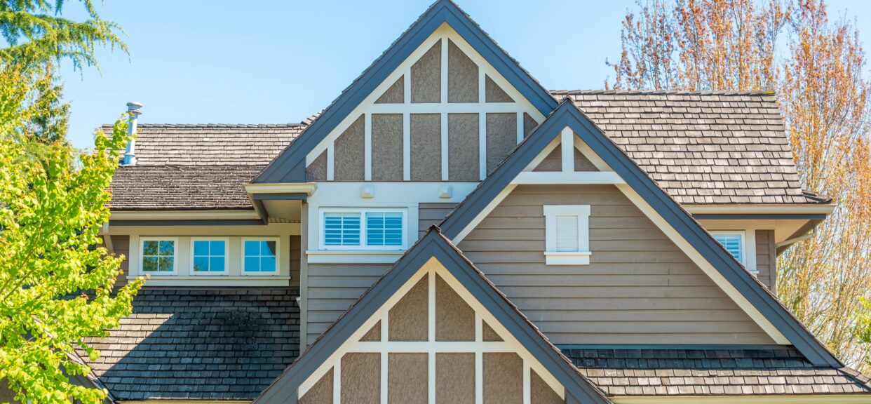 Craftsman-style home exterior with small gable windows and Tudor-inspired trim, small window replacement ideas