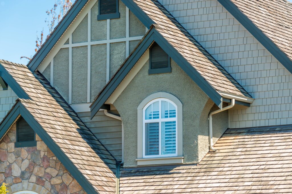 close-up of small arched dormer window with white casing on Craftsman roofline, Canadian home window replacement