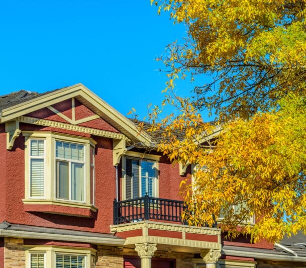 Red house with yellow autumn leaves.