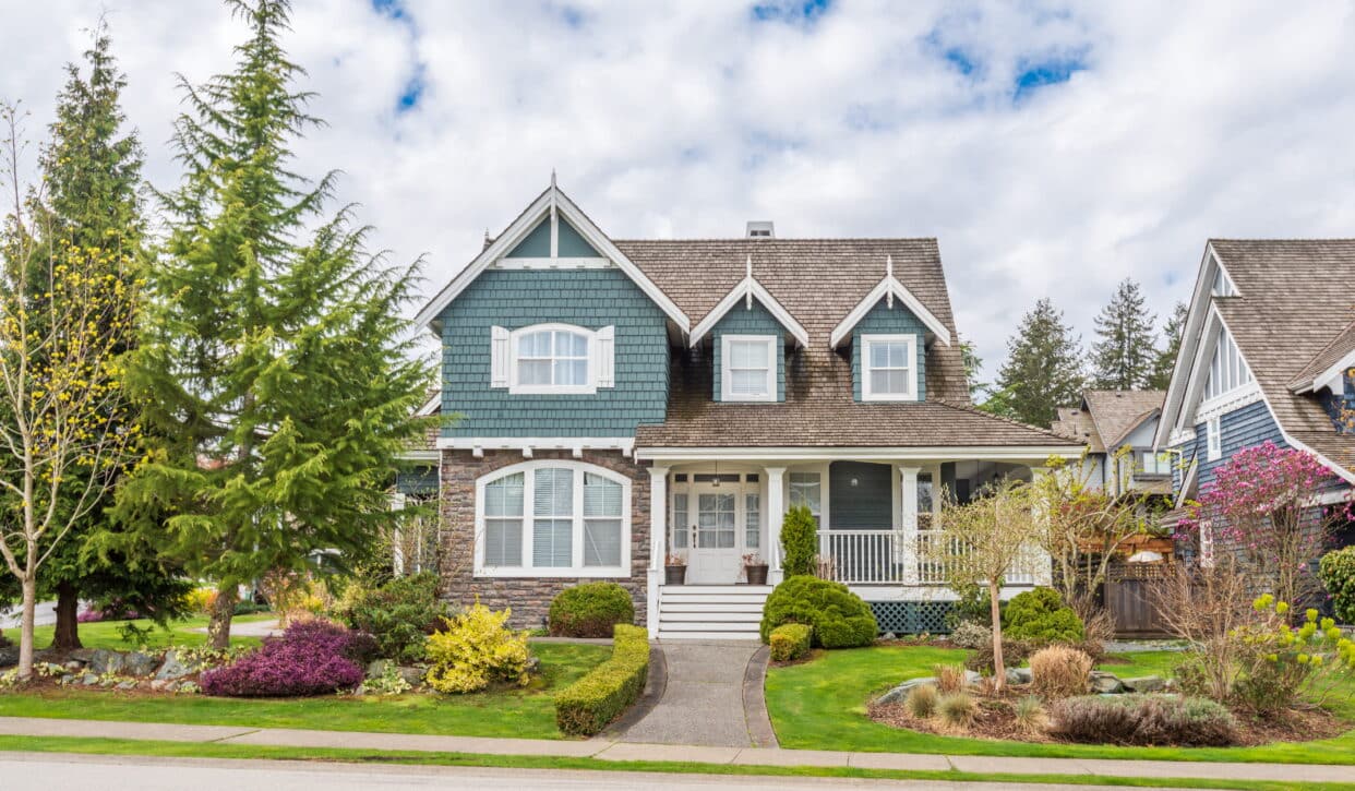Craftsman-style home in Terrace, Ontario with replaced arched and double-hung windows on teal shingle exterior — HTR Windows and Doors